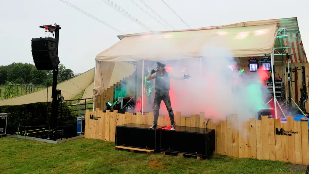 Het houten podium in de boomgaard, in rook en licht